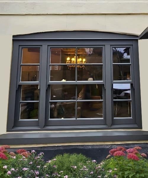 Exterior view of timber sash windows painted in dark grey, demonstrating dual colour paint option with contrasting internal colour.
